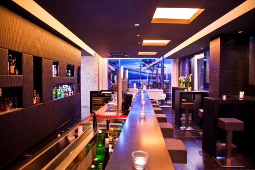 a bar with a long counter in a restaurant at Lake's - My Lake Hotel in Pörtschach am Wörthersee