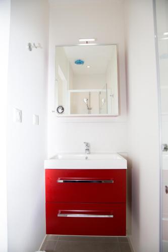 a bathroom with a red sink and a mirror at Albipavillon in Albi