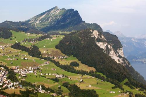 a village in a valley with a mountain at Hotel Arvenbüel in Amden