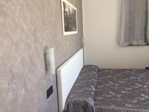 Dormitorio pequeño con cama con sábanas moradas en B&B Villa Elena, en Furci Siculo