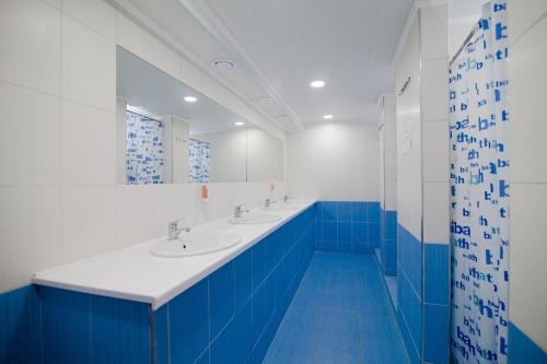 a blue and white bathroom with two sinks and a mirror at Gar'is Hostel Kyiv in Kyiv