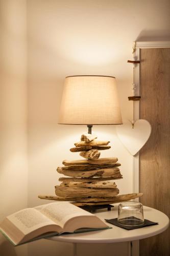 una mesa con una lámpara, un libro abierto y un libro en CircEea Beach B&B, en San Felice Circeo