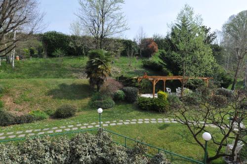 a garden with a wooden arch and a fence at Hotel Fossati in Triuggio