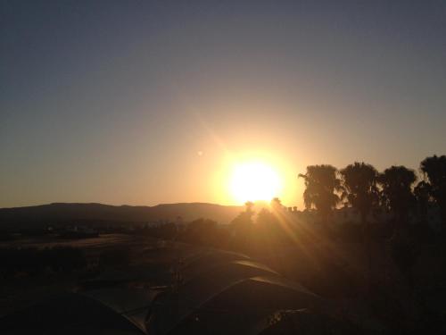 a sunset over a golf course with the sun in the sky at Latchi Holiday Flat in Polis Chrysochous