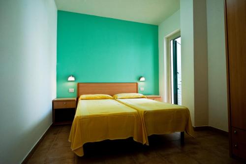 Tempat tidur dalam kamar di Villaggio Turistico Le Diomedee