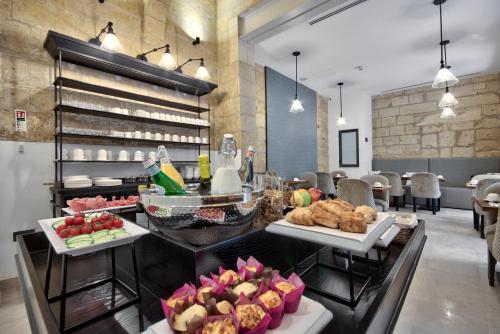 a buffet line with food on display in a restaurant at 66 Saint Paul's & Spa in Valletta
