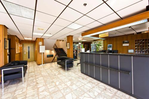 a lobby with a bar and chairs and stairs at Beth-Shalom in Haifa