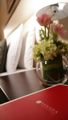 a table with a vase of flowers on it at Ramada Hotel & Suites by Wyndham Ajman in Ajman 