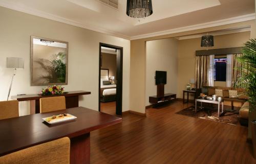 a living room with a table and a couch at Ramada Hotel & Suites by Wyndham Ajman in Ajman 