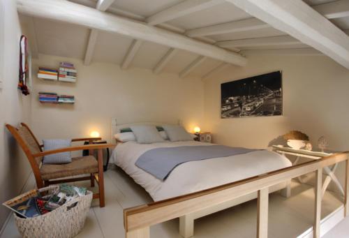 リド・ディ・カマイオーレにあるAppartamento Libeccioのベッドルーム1室(ベッド1台、テーブル、椅子付)