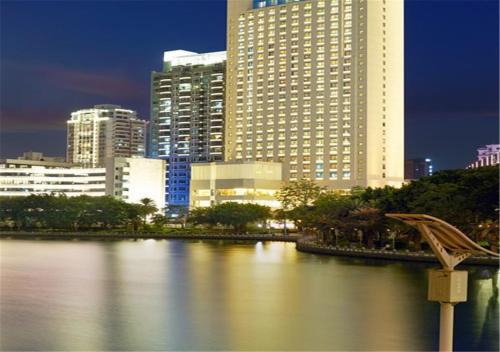 Xiamen Airlines Lakeside Hotel في شيامن: اطلالة على مدينة فيها مباني طويلة ونهر