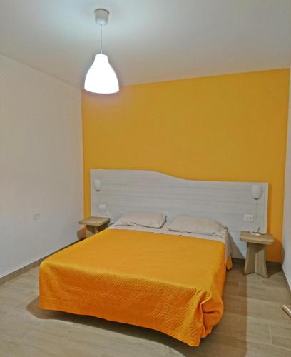 a bedroom with an orange bed with two tables at La Duchessa e Il Contadino in Vieste