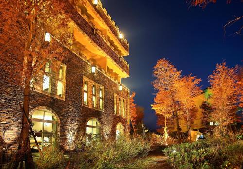 a brick building at night with lights on at Huis Ten Bosch in Renai