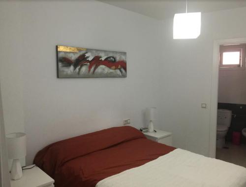 ロンダにあるM.L Los Vicentesのベッドルーム1室(ベッド1台付)が備わります。壁には絵画が飾られています。