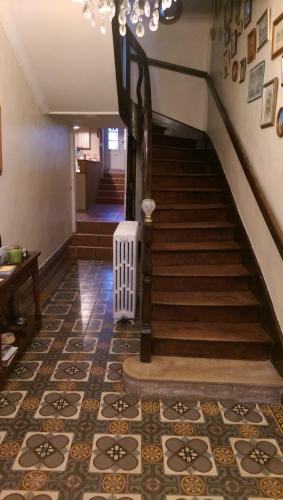 a hallway with a staircase with a chandelier at Vingt Grand Rue in Champagne-Mouton