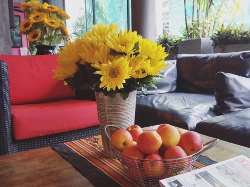 a vase with yellow flowers and fruit on a table at Baipho Lifestyle in Patong Beach