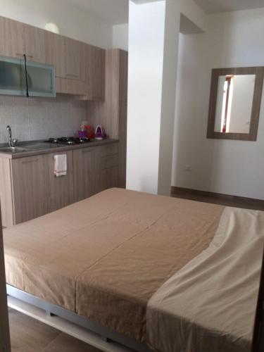 a large bed in a room with a kitchen at La Duchessa e Il Contadino in Vieste