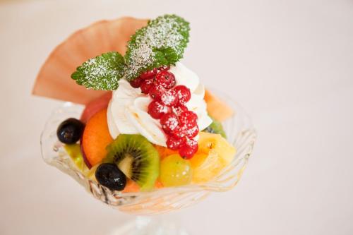 a bowl of fruit with whipped cream and vegetables at Hotel Arvenbüel in Amden