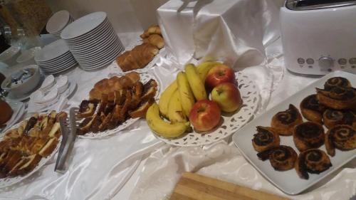 a table topped with plates of fruit and pastries at Hotel Mara in Baia Mare