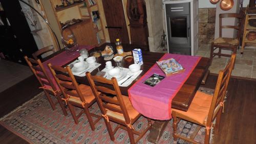 einen Esstisch und Stühle mit einem lila Tischtuch in der Unterkunft Le Mas de Cascabel in Causse et Diege