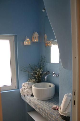a blue bathroom with a tub and a mirror at La Casetta 19 in Polignano a Mare