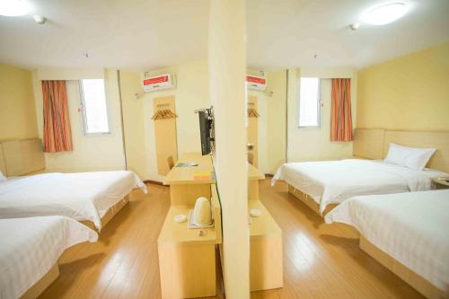 a hotel room with two beds and a television at 7Days Inn Huizhou West Lake in Huizhou