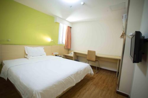 a bedroom with a bed and a desk and a television at 7Days Inn Huizhou West Lake in Huizhou