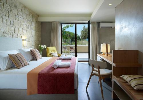 a bedroom with a large bed with a desk and a desk at Mistral Hotel - For Solo Travelers in Maleme