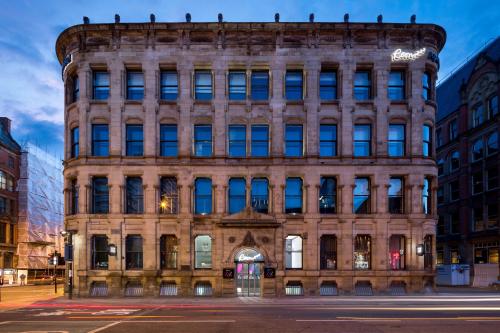 an old building in the city at night at Roomzzz Manchester City in Manchester