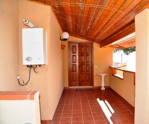 a hallway with a wooden door and a tile floor at Villa Incanto B&B in Caprioli