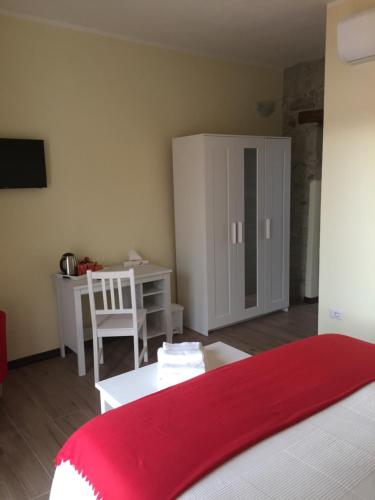 a bedroom with a bed and a table and a desk at Bomarosa B&B in Bosa