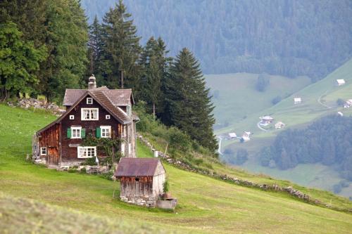 an old house on the side of a hill at Hotel Arvenbüel in Amden