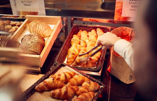 una persona que busca una bandeja de bollería en una panadería en WestCord Art Hotel Amsterdam 4 stars, en Ámsterdam