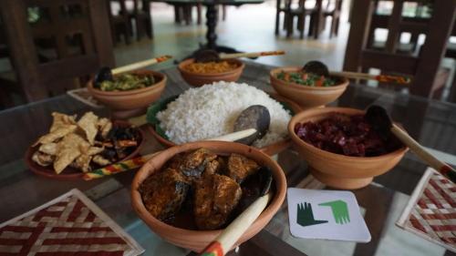 a table topped with bowls of food and rice at Vihanga Village - Jungle retreat in Dambulla in Dambulla