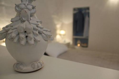 a white vase sitting on top of a table at La Casetta 19 in Polignano a Mare