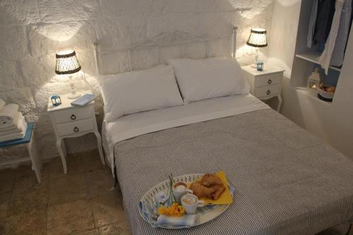 a bedroom with a bed with a tray of food on it at La Casetta 19 in Polignano a Mare