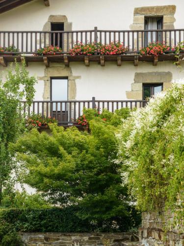 a building with a balcony with flowers on it at Hotel Akerreta in Akerreta