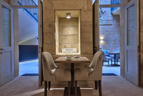 a dining room with a table and chairs at 66 Saint Paul's & Spa in Valletta