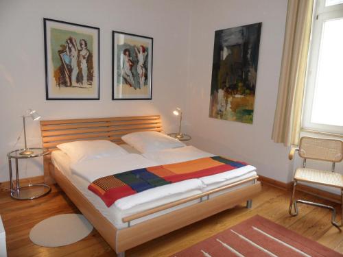 a bedroom with a bed and paintings on the wall at Villa Carola - 100 m zum Strand in Heringsdorf