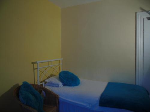 a bedroom with a bed with blue pillows on it at Victoria Guest House in Bedford