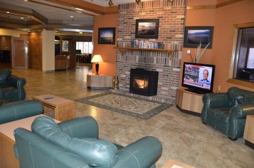 a lobby with a fireplace and couches and a tv at Tawas Bay Beach Resort & Conference Center in East Tawas