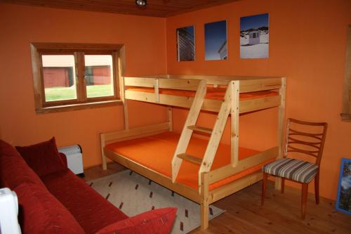 Etagenbett in einem Zimmer mit Sofa und Stuhl in der Unterkunft Ahornfarm Håkannäs in Kristinehamn