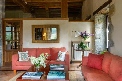 a living room with red couches and a table at Hotel Akerreta in Akerreta