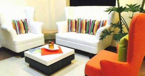 a living room with two chairs and a coffee table at Bayview Country Inn El Nido in El Nido