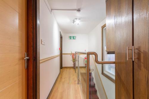 a hallway with a staircase with a vase of flowers at Brick Lane Hotel in London