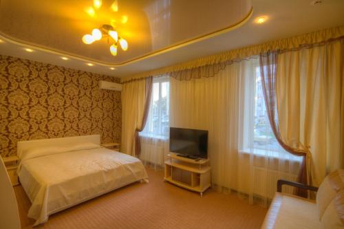 a bedroom with a bed and a flat screen tv at Siesta Hotel in Kharkiv