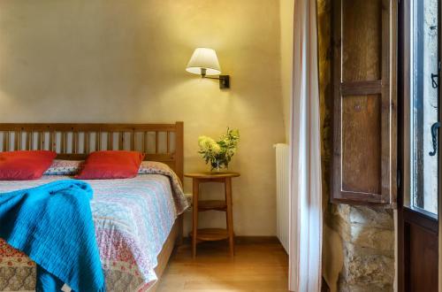a bedroom with a bed and a table with a lamp at Hotel Akerreta in Akerreta