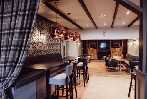 a bar with chairs and tables in a restaurant at Richmond Park Hotel in Boʼness