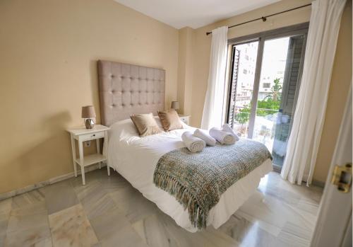 マラガにあるAcogedor apartamento junto a calle Larios by Renthasのベッドルーム1室(ベッド1台、大きな窓付)
