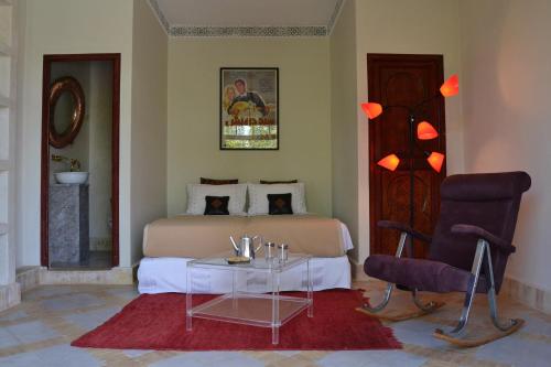 a bedroom with a bed and a table and chairs at Riad El Arsat & Spa in Marrakech